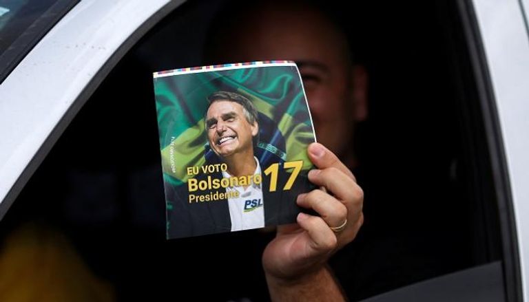 أحد مؤيدي بولسونارو خلال مسيرة انتخابية في برازيليا - رويترز