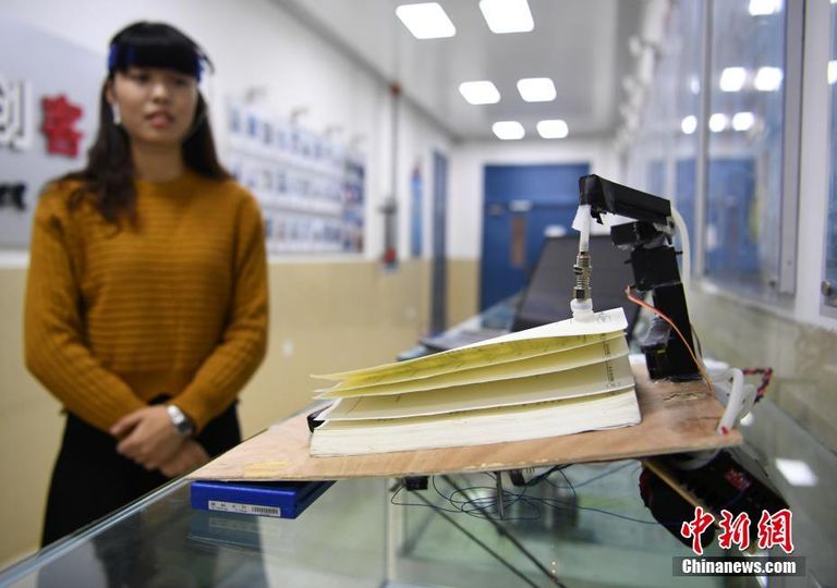 طالبة تحرك صفحات الكتاب باستخدام أفكار الدماغ