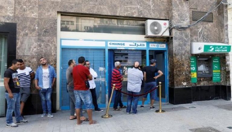 تونسيون أمام إحدى شراكات الصرافة - الصورة من رويترز
