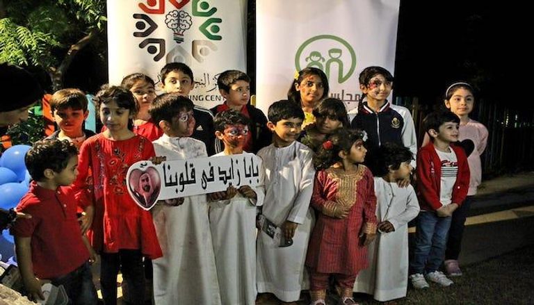 أطفال يرفعون شعار "بابا زايد في قلوينا"