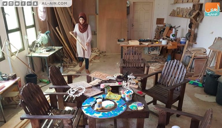 الفنانة الفلسطينية ولاء أبوالعيش أمام إحدى لوحاتها