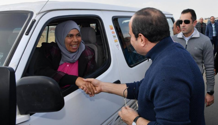 السيسي يصافح سيدة تعمل سائقة بالعاصمة الإدارية
