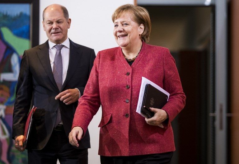 ميركل ووزير المالية الألماني أولاف شولتر  الرئيس الفرنسي إيمانويل ماكرون