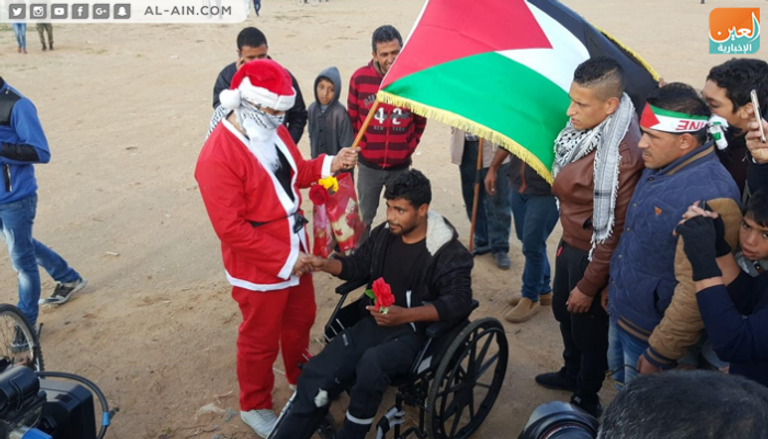 بابا نويل الفلسطيني يوزع الورود على متظاهري العودة بغزة