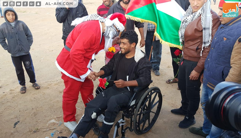 بابا نويل الفلسطيني يوزع الورود على متظاهري العودة بغزة