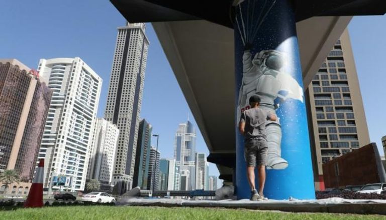 فنان يرسم على أحد الأعمدة في دبي