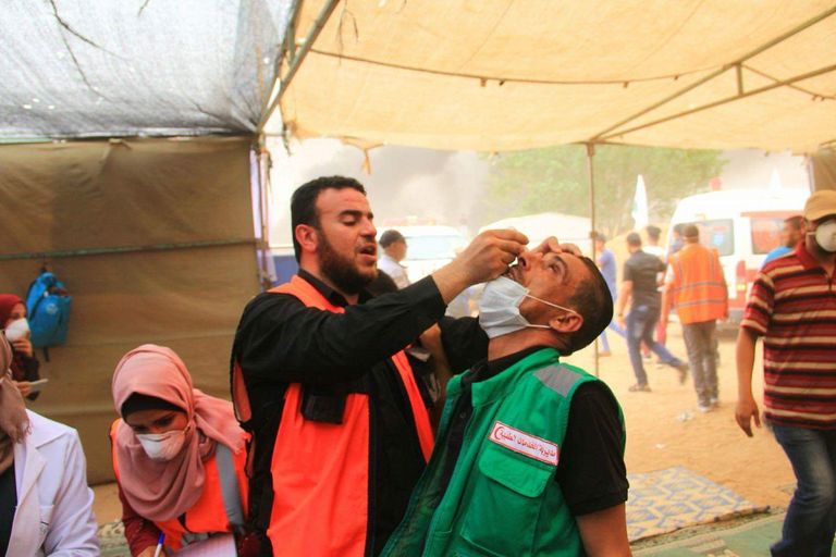 مسعف فلسطيني يعالج زميله الذي أصابته قوات الاحتلال الإسرائيلي جرحى في غزة خلال مسيرة العودة الكبرى - أرشيفية
