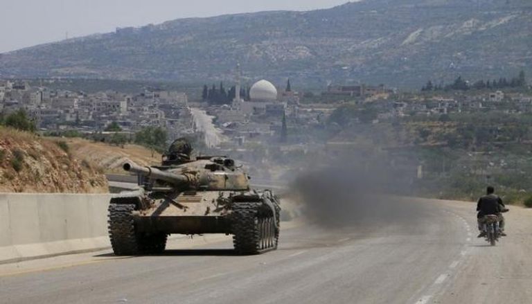 مقاتلون من جماعة جند الأقصى يقودون دبابة على طريق في إدلب