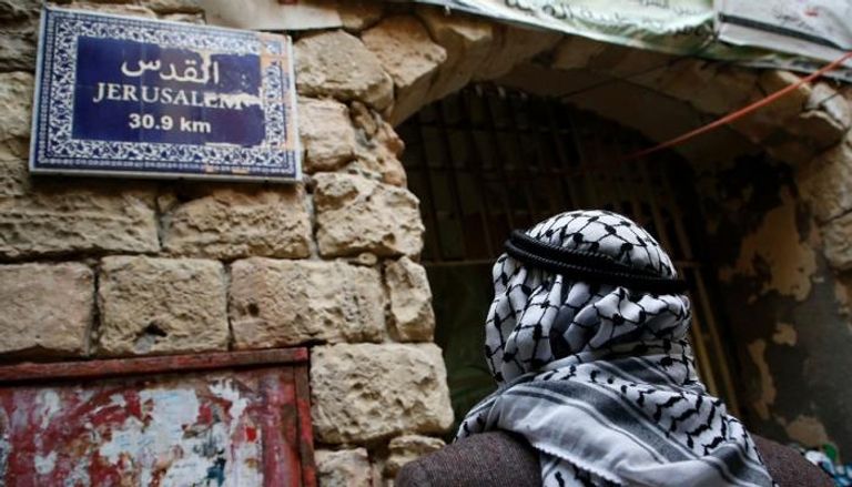 فلسطيني في القدس المحتلة الرئيسان الأمريكي ترامب والفلسطيني محمود عباس - أرشيفية