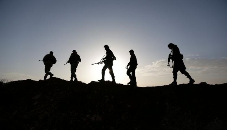 مقاتلون يسيرون بإحدى الجبهات في سوريا (رويترز)