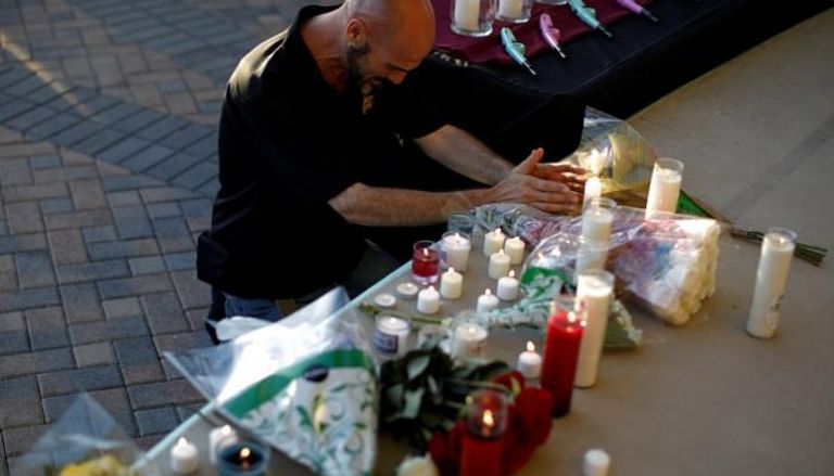 شموع وزهور على قبر رمزي لضحايا الحادث - رويترز