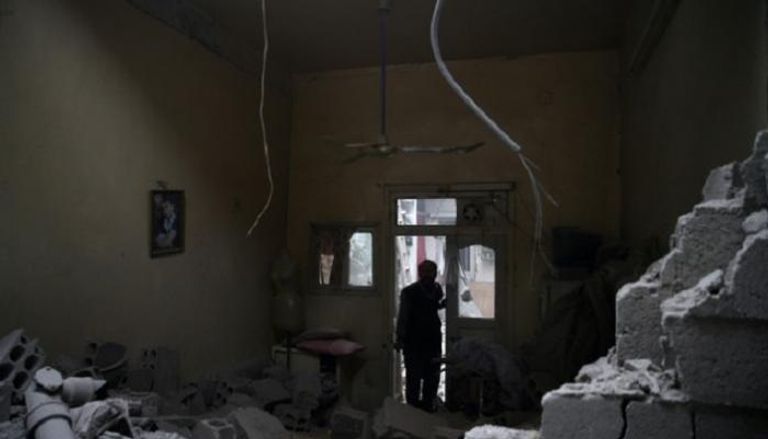 سوري يتفقد آثار الدمار الذي لحق بمنزله في الغوطة الشرقية