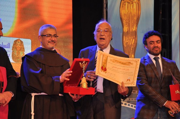 الفنانة ليلى طاهر إلى جوار لافتة المهرجان