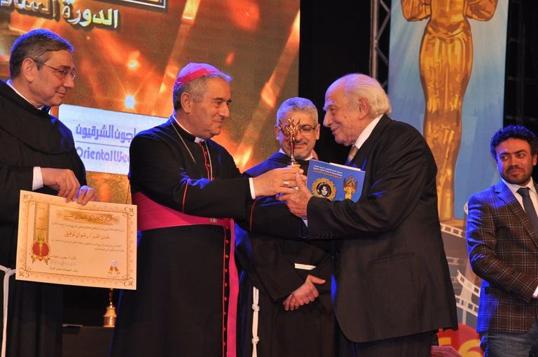 الفنانة ليلى طاهر إلى جوار لافتة المهرجان