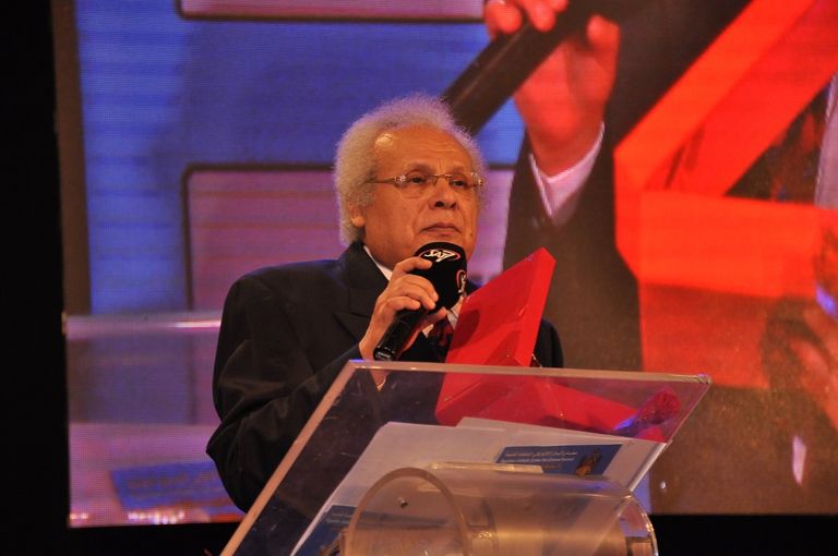 الفنانة ليلى طاهر إلى جوار لافتة المهرجان