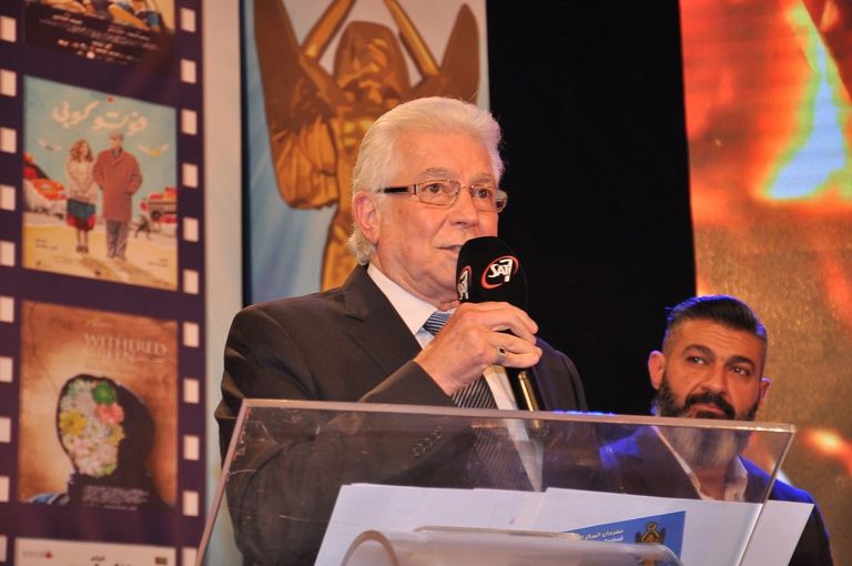 الفنانة ليلى طاهر إلى جوار لافتة المهرجان