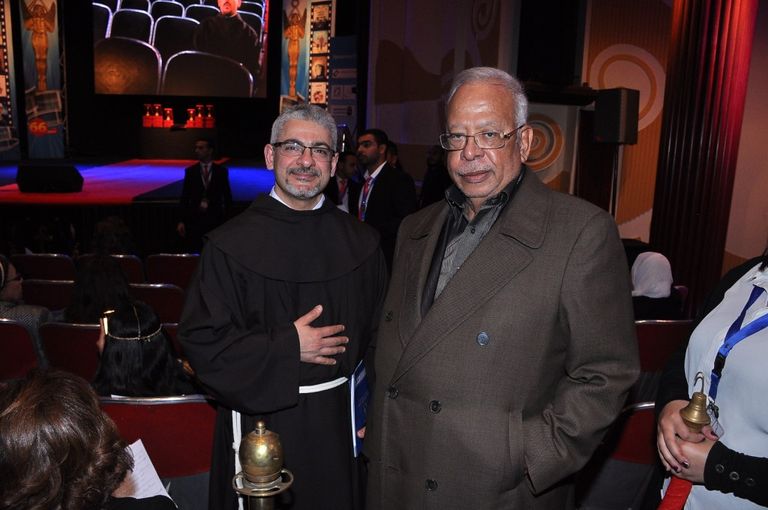 الفنانة ليلى طاهر إلى جوار لافتة المهرجان