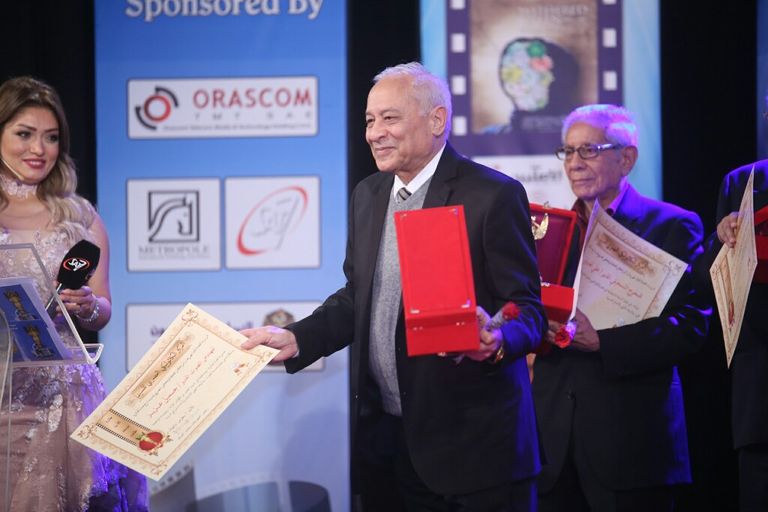 الفنانة ليلى طاهر إلى جوار لافتة المهرجان