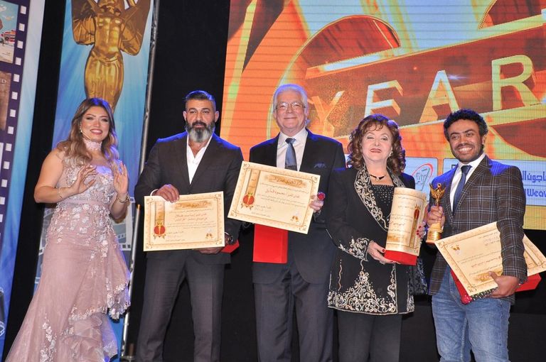 الفنانة ليلى طاهر إلى جوار لافتة المهرجان