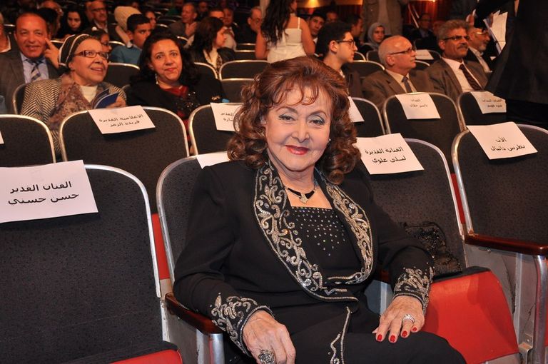 الفنانة ليلى طاهر إلى جوار لافتة المهرجان