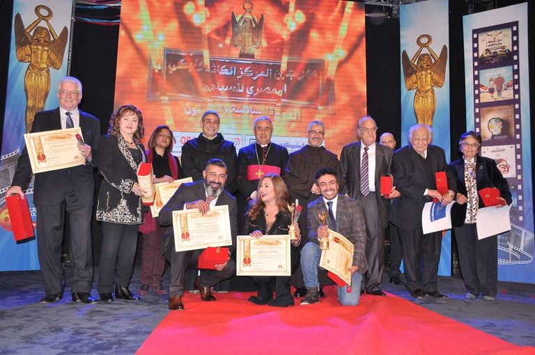 الفنانة ليلى طاهر إلى جوار لافتة المهرجان