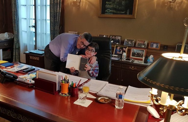 الطفل عماد شيالي يجلس على مكتب السفير الجزائري في فرنسا