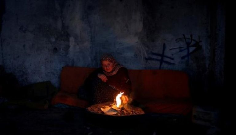 امرأة فلسطينية تحرق بعض الأوراق للتدفئة في قطاع غزة