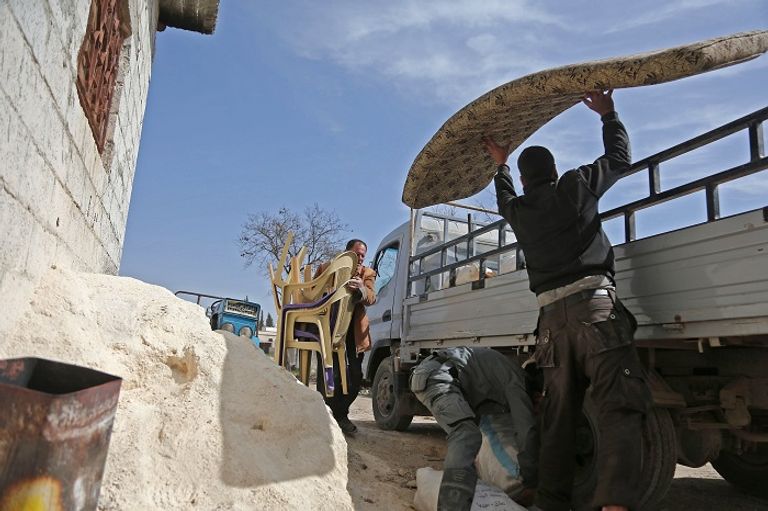 السوريون يفرون من بيوتهم جراء القصف العنيف على الغوطة الشرقية- أ.ف.ب طفل سوري ينظر إلى مبنى مدمر جراء قصف الغوطة الشرقية- أ.ف.ب