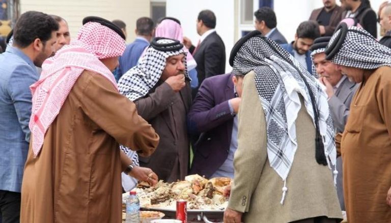 عراقيون يتشاركون الطعام في الأنبار (أ.ف.ب)