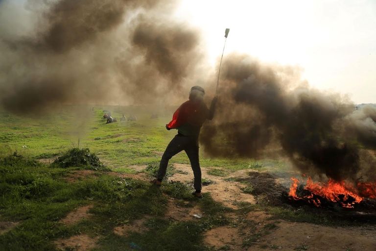 شاب فلسطيني يحمل مقلاعا خلال مواجهات مع جيش الاحتلال شبان فلسطينيون يحملون جريحا خلال مواجهات مع قوات الاحتلال