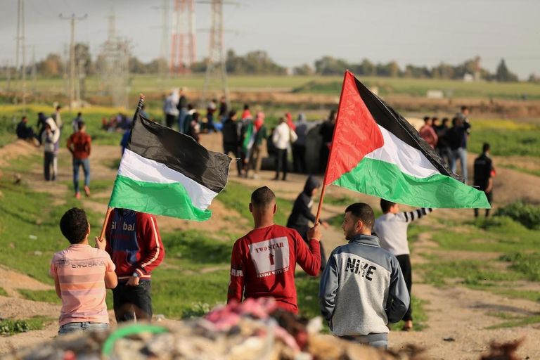 متظاهرون فلسطينيون يرفعون العلم الفلسطيني نصرة للقدس شبان فلسطينيون يحملون جريحا خلال مواجهات مع قوات الاحتلال