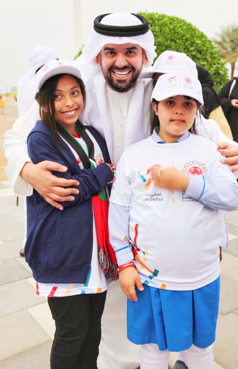 حسين الجسمي مع طفلتين أثناء حضوره مبادرة نمشي معا لأصحاب الهمم الجسمي يشارك في المبادرة