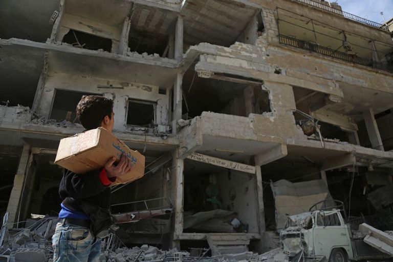 طفل سوري ينظر إلى مبنى مدمر جراء قصف الغوطة الشرقية- أرشيفية آثار القصف العنيف على الغوطة الشرقية- أ.ف.ب