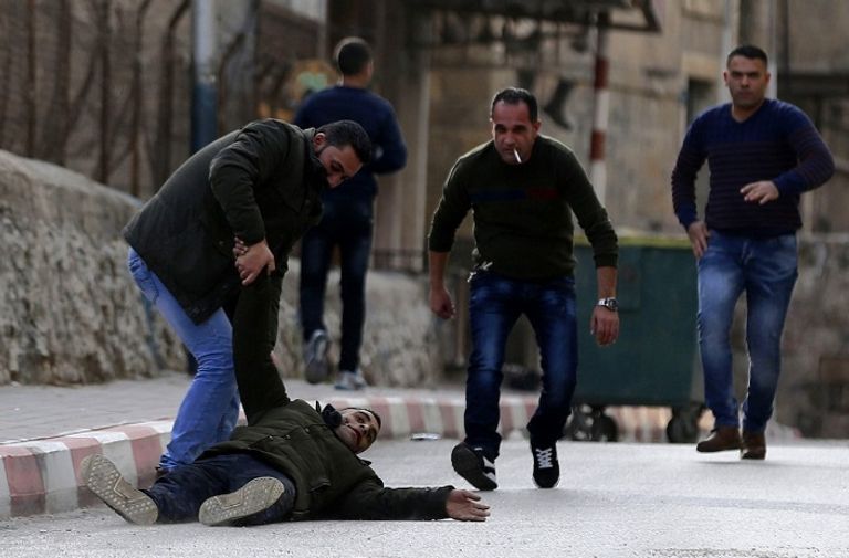فلسطيني مصاب بقوات الاحتلال مجموعة من الشباب يحملون مصابا برصاص الاحتلال - رويترز