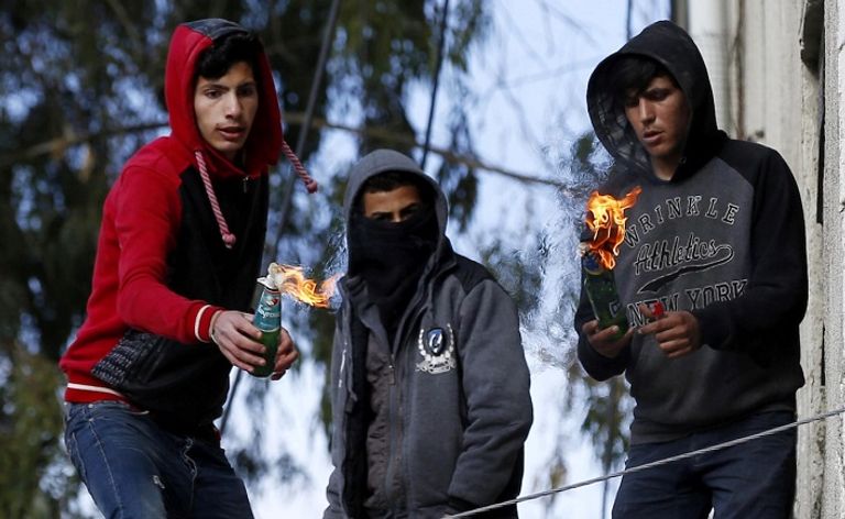 مجموعة من الشباب تلقي بزجاجات حارقة على قوات الاحتلال مجموعة من الشباب يحملون مصابا برصاص الاحتلال - رويترز