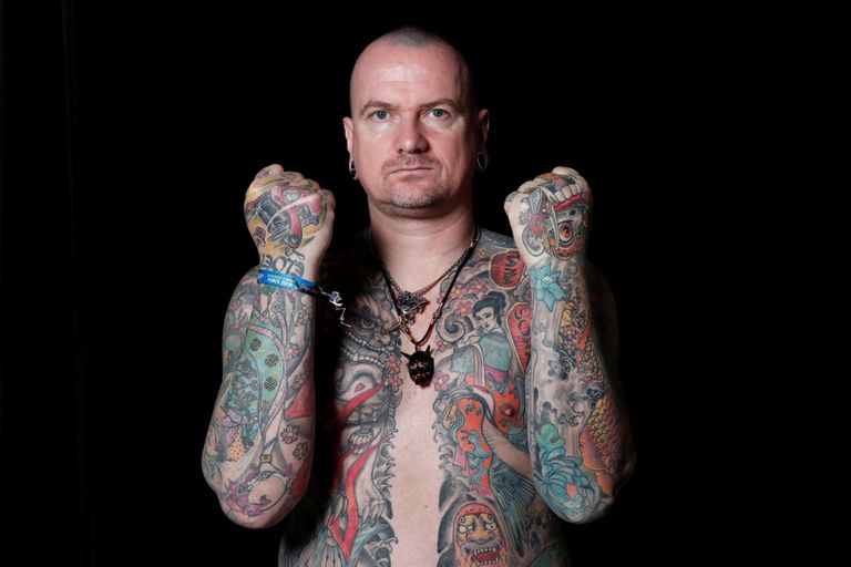 شاب يستعرض رسوم التاتو على جسده