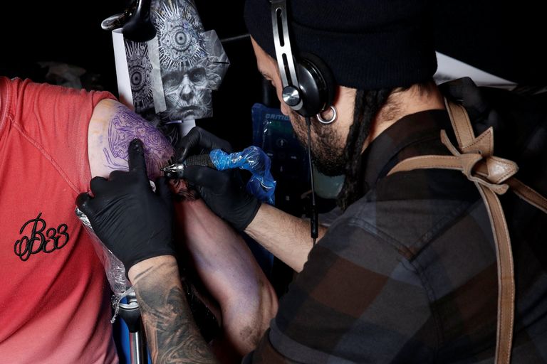 شاب يستعرض رسوم التاتو على جسده