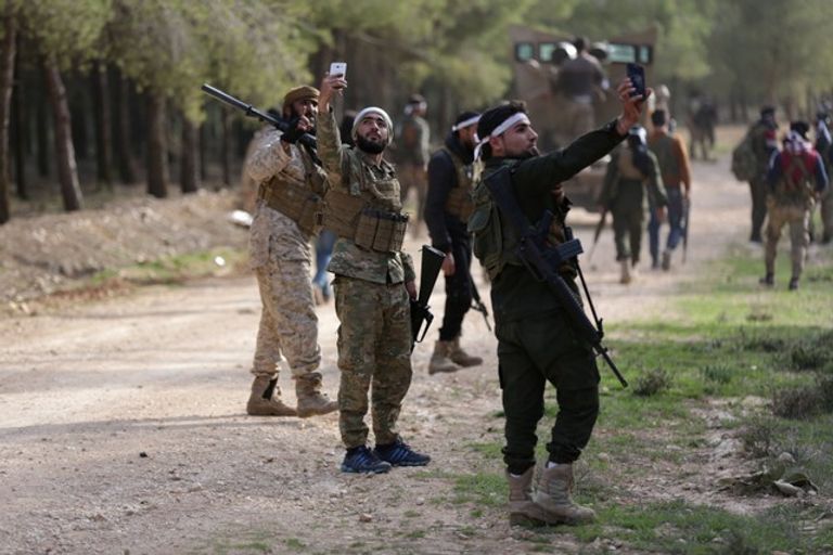 عناصر تابعة للجيش التركي يلتقطون الصور ولا يأبهون بمعاناة أهالي  عفرين مقاتلون تابعون للجيش التركي قرب عفرين