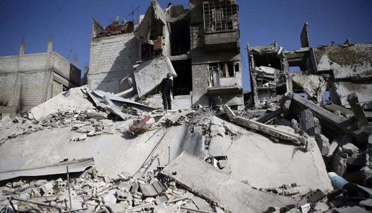 رجل يقف وسط الدمار جراء قصف قوات النظام للغوطة - رويترز