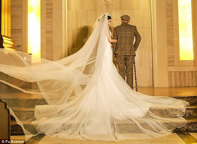 الفتاة تتبطأ ذراع جدها في حفل الزفاف الوهمي فو تحاول تحقيق أمنية جدها برؤيتها عروساً قبل وفاته