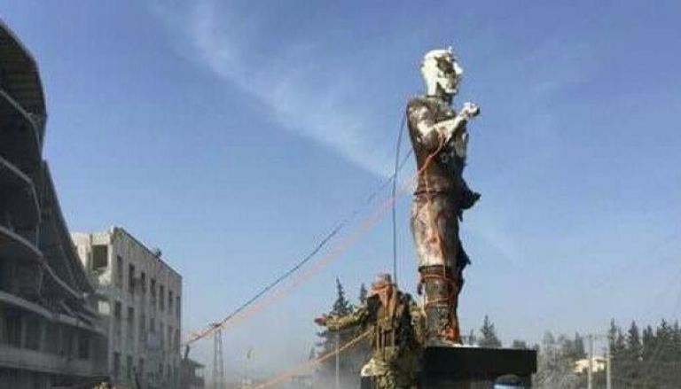 قوات موالية لتركيا أثناء تدمير تمثال 