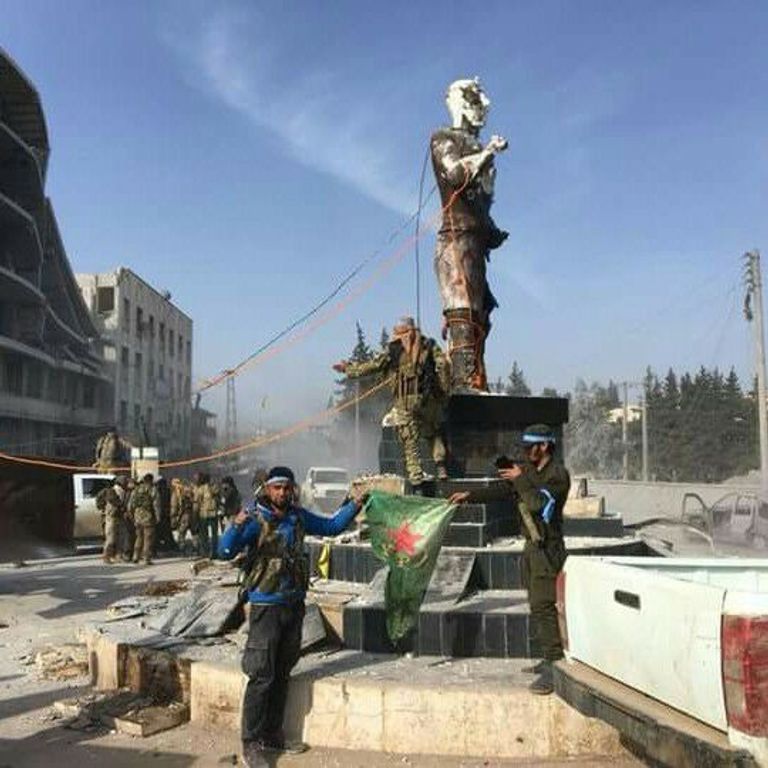 قوات موالية لتركيا أثناء تدمير تمثال