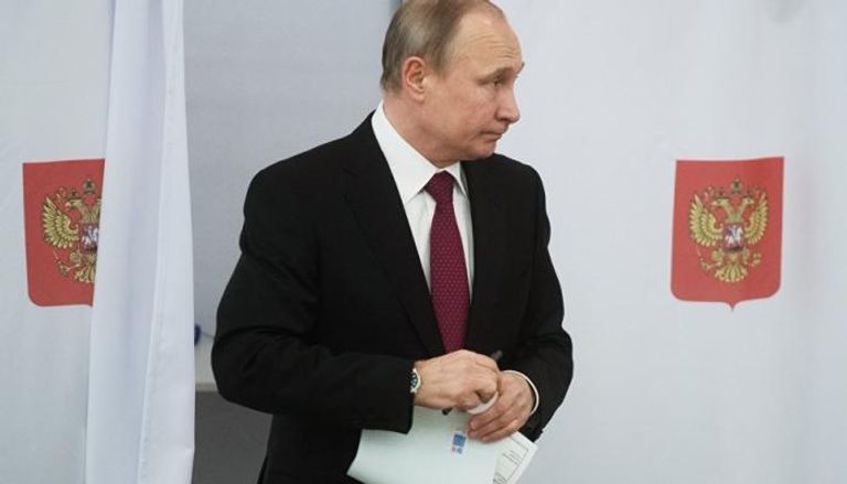 بوتين ممسكا بقلمه بعد التصويت