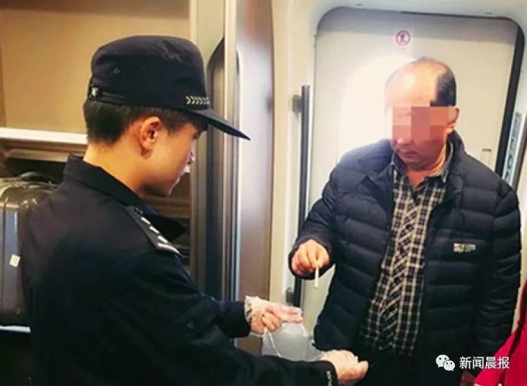 أحد المدخنين يسلم سجائره لمفتش القطارات حظر المدخنين من السفر في الصين