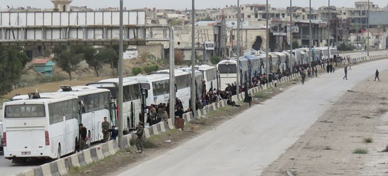 الحافلات تنتظر نقل المدنيين والمقاتلين خارج الغوطة المدنيون والمقاتلون يستعدون للخروج من الغوطة