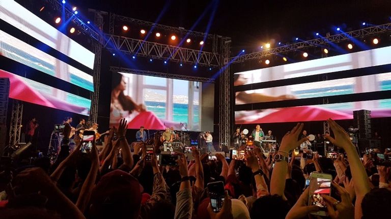 محبو عمرو دياب يلتقطون له الصور عمرو دياب في حفل الجامعة الأمريكية بالقاهرة