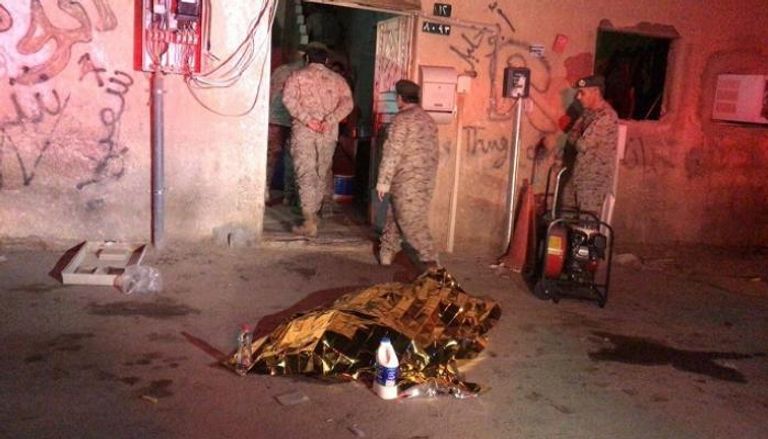 جنود سعوديون يتفقدون آثار شظايا صاروخ حوثي