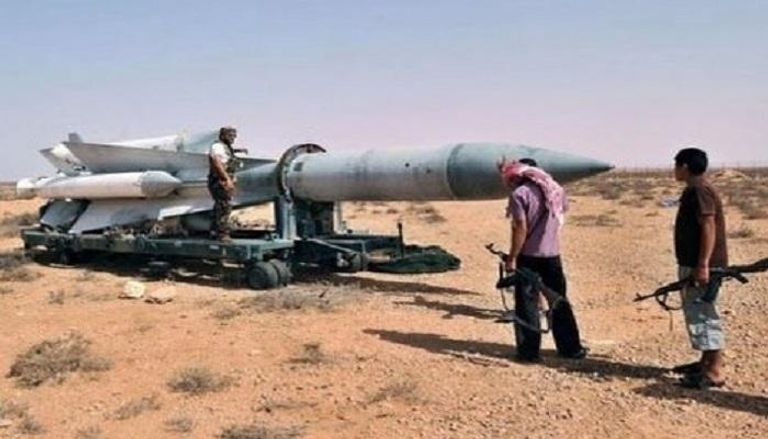 جنود سعوديون يتفقدون آثار شظايا صاروخ حوثي