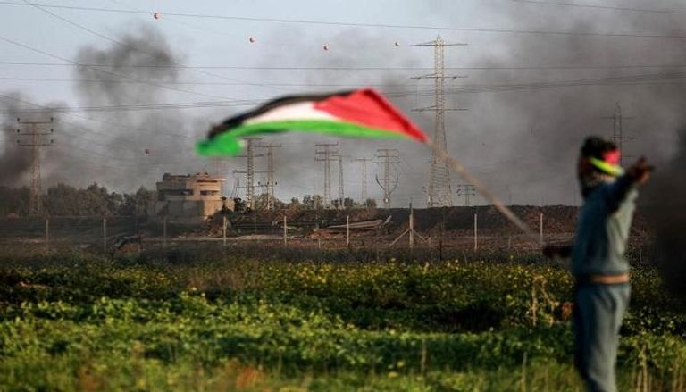 فلسطيني يواجه غارة إسرائيلية على غزة - أرشيف