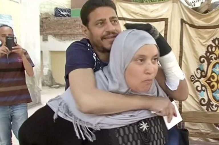 سيدة مصرية تحمل زوجها على ظهرها المصريون أمام لجان الانتخاب